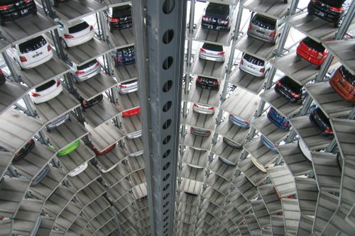 A vertical view of a spiral multi-storey car park filled with vehicles.