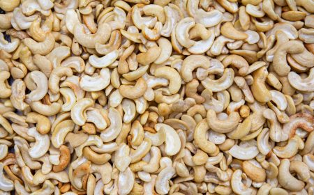 A detailed close-up of roasted cashew nuts creating a textured, appetizing backdrop.